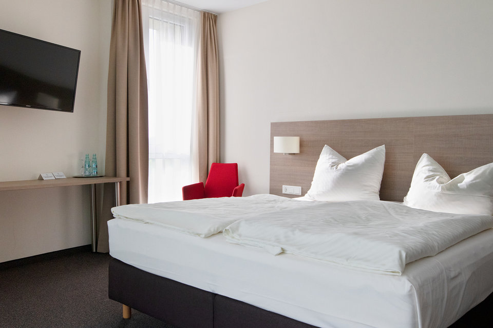 Hotelzimmer im Hotel Susato - Doppelbett mit Fernseher